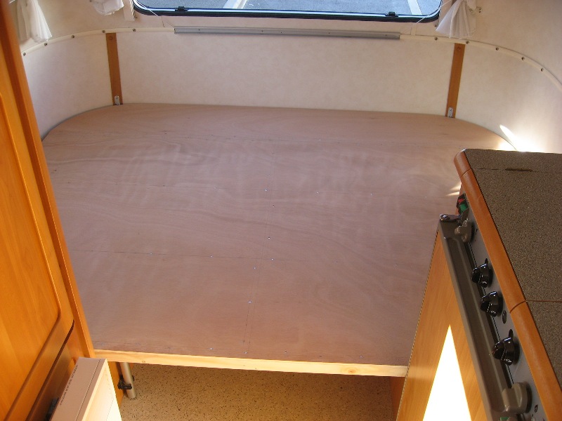 les 2 parties en place, la partie arrondie est solidarisée du support des coffres laissés en place, des 3 cornières entre les 2 parties permettent au sommier d'être soulevé. pas de cadre autour permet au matelas de glisser librement pendant l'ouverture.