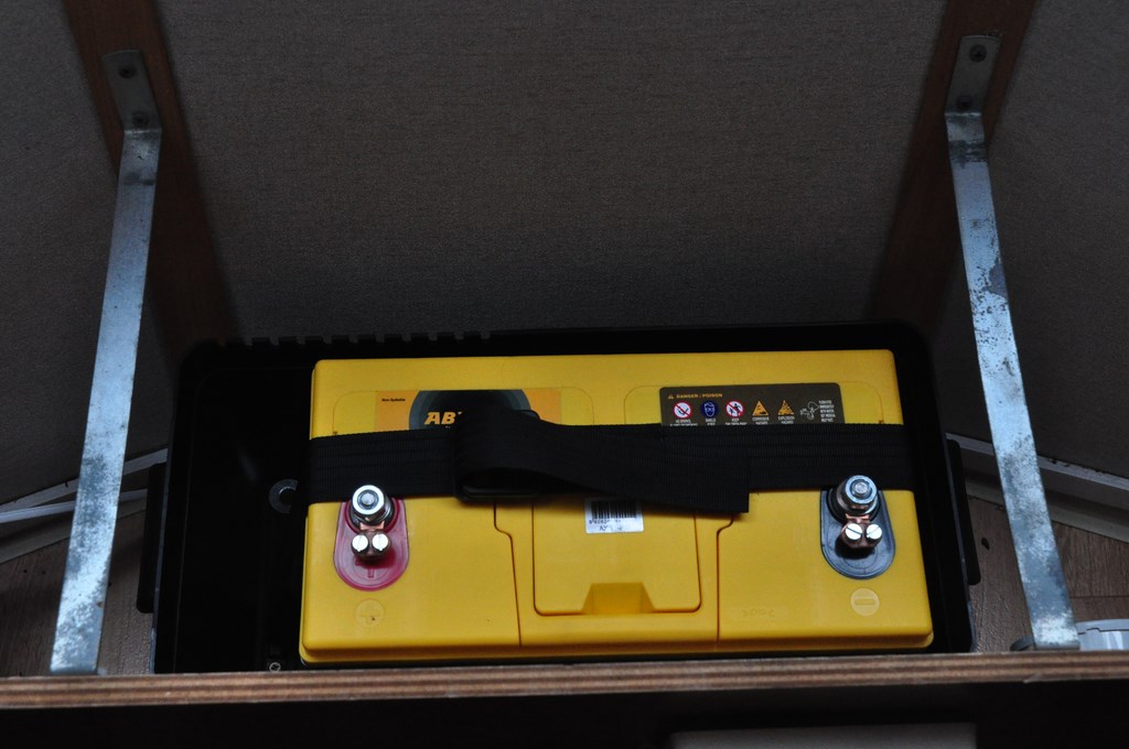 La batterie est sanglée dans un caisson plastique